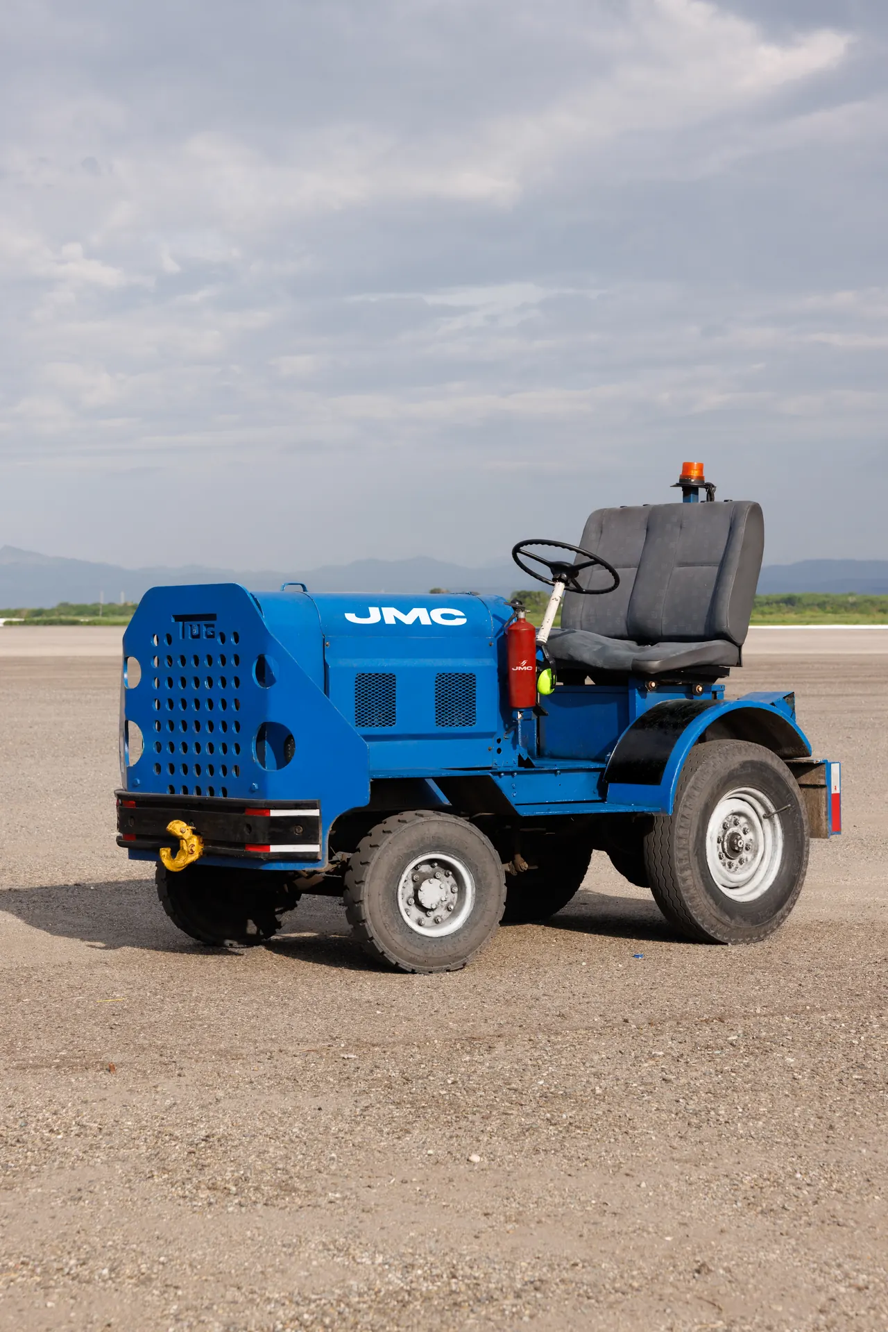 Tractor remolcador de plataforma con asiento de conductor, volante y rótulos JMC