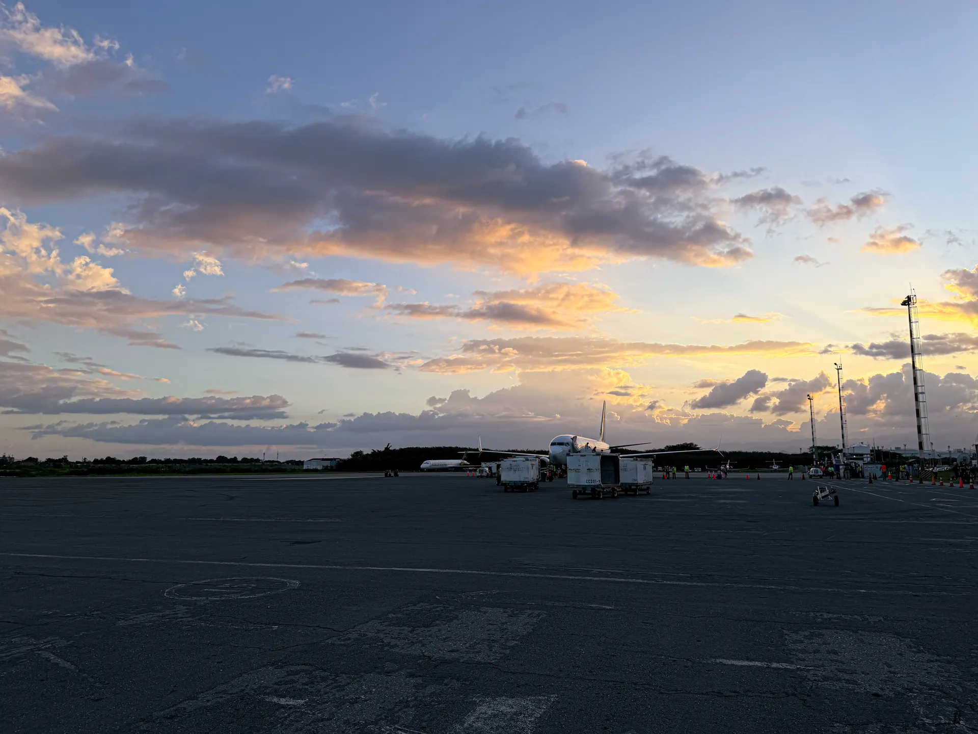 Rampa del aeropuerto de Maiquetía al anochecer, con una aeronave iluminada y equipos de apoyo terrestre sobre la plataforma